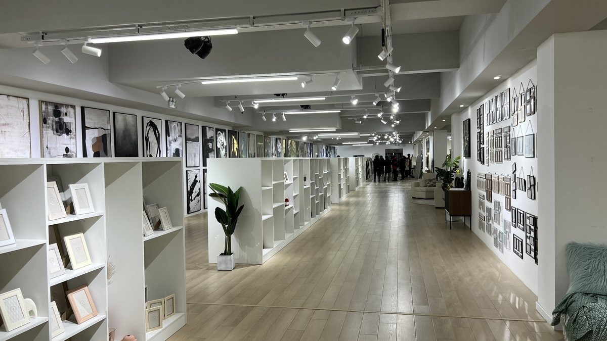 中国の工場に併設されたショールーム。壁と棚にアートフレームや額縁の商品サンプルが展示されている